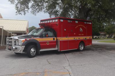 Side view of a red Alma/Bacon County Emergency Fire/EMS truck